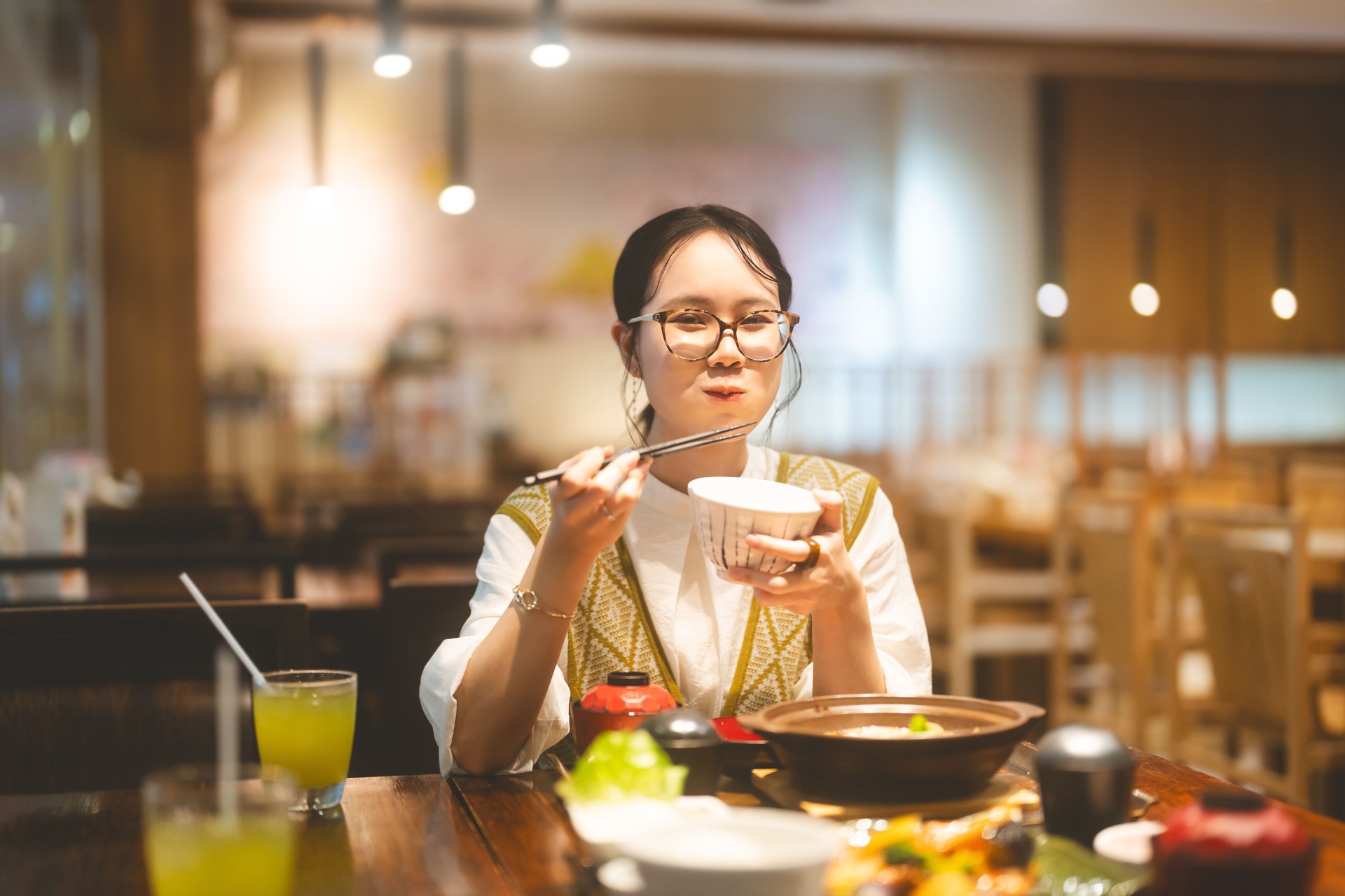 Happy asian woman holding rice bowl eating food at Japanese restaurant asia tasty from traditional culture
